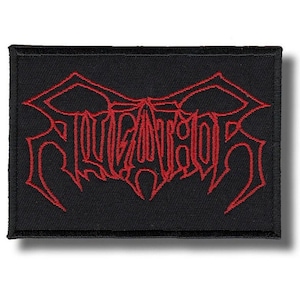 May include: Black rectangular patch featuring the word "SLUGATOR" in red, gothic-style embroidery. The patch has a black border and is designed to be sewn or ironed onto clothing or accessories.