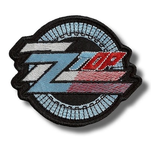 May include: Embroidered patch featuring the word "TOP" in red and white, with a stylized "Z" in blue and white. The patch has a black border with a light blue decorative ring.