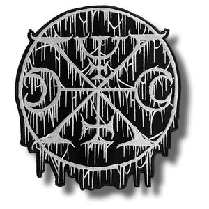 May include: A black and white embroidered patch with a circular design. The design features a central symbol within a circle, with intricate lines and a dripping effect. The patch is likely for clothing or accessories.