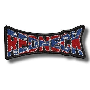 May include: Embroidered patch with the word "REDNECK" in red and blue, stitched onto a black background. The design features a stylized font with a flag-like pattern within the letters. The patch has a curved, bow-tie shape.