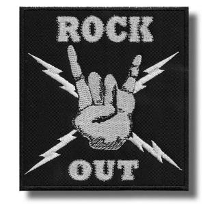Può includere: Toppa quadrata nera con testo e disegno ricamati in bianco. Il testo recita "ROCK OUT" con un gesto della mano e fulmini. La toppa è probabilmente per una giacca o una borsa.