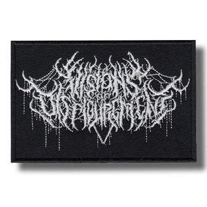 Könnte beinhalten: Schwarzer rechteckiger Aufnäher mit weiß gesticktem Text. Der Text ist stilisiert und scheint ein Bandlogo oder ein ähnliches Design zu sein. Der Aufnäher hat einen schwarzen Rand und einen Schatteneffekt.