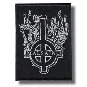 Puede incluir: Parche rectangular negro con un diseño bordado en blanco. El diseño presenta una cruz con un elemento circular en el centro, la palabra "MALSAINT" debajo y figuras estilizadas arriba. El parche tiene un borde negro.