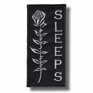 Broderad lapp med strykmärke "Medan hon sover" 1c1340