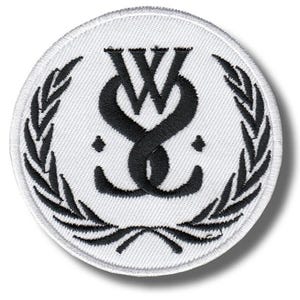 May include: A round, white patch with a black emblem. The emblem features intertwined letters "W" and "S" above two small dots, surrounded by a laurel wreath. The patch has a stitched border.