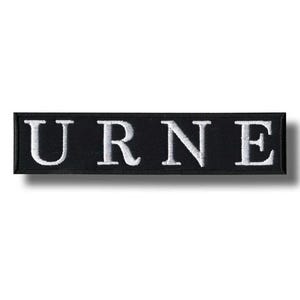 Puede incluir: Parche rectangular negro con la palabra "URNE" bordada en letras mayúsculas blancas. El parche tiene un borde blanco y un efecto de sombra, lo que sugiere un diseño en relieve. Ideal para ropa o accesorios.