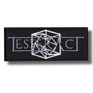 Op de afbeelding: Zwart geborduurde rechthoekige patch met het woord "ESPERA" in grijs, overlegd met een wit geometrisch ontwerp. De patch heeft een zwarte rand.