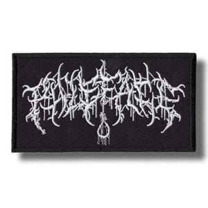 Puede incluir: Parche rectangular negro con letras góticas blancas bordadas y un diseño de soga. El parche es probablemente para una chaqueta o bolso, y presenta una estética de heavy metal o punk rock.
