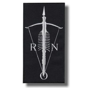 Pode incluir: Patch retangular preto com um design bordado branco. O design apresenta uma coluna vertebral estilizada, um elemento semelhante a uma lança e as letras "R" e "N". Um elemento circular está na parte inferior. O patch é provavelmente para roupas ou acessórios.