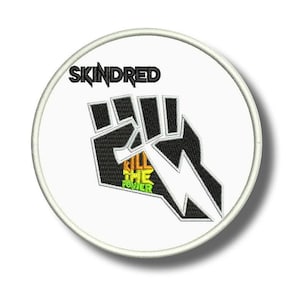 May include: Embroidered patch with a white background. It features a black and white fist design, with the text "SKINDRED" above. The words "KILL THE POWER" are inside the fist in yellow and green.