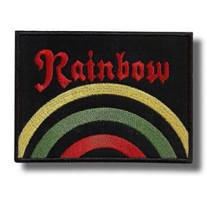 Könnte beinhalten: Schwarzer rechteckiger Aufnäher mit dem Wort "Rainbow" in roter Schrift über einem gelben, grünen und roten Regenbogen-Design. Der Aufnäher hat einen schwarzen Rand und ist für Kleidung oder Accessoires bestimmt.