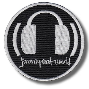 May include: Round black patch with a white embroidered design of headphones inside a circle. The text "Jimmy Eat World" is written in white script below the headphones. The patch has a white border.