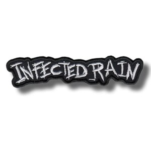 Könnte beinhalten: Ein schwarzer, gestickter Aufnäher mit dem weißen Schriftzug "INFECTED RAIN" in einem stilisierten Design. Der Aufnäher hat einen schwarzen Rand und ist zum Aufnähen oder Aufbügeln auf Kleidung oder Accessoires gedacht.