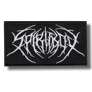 May include: Black rectangular patch featuring the white text "SPIRITBOX" in a gothic font. The text has a spiky, organic design. The patch is designed for application on clothing or accessories.