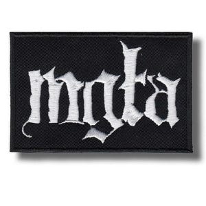Pode incluir: Patch retangular preto com a palavra "mnta" bordada em branco em uma fonte gótica. O patch tem uma borda preta e uma aparência texturizada. Adequado para roupas ou acessórios.
