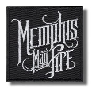 Puede incluir: Parche cuadrado negro con texto bordado blanco que dice "Memphis May Fire" en una fuente gótica estilizada. El parche tiene un borde negro y un efecto de sombra.