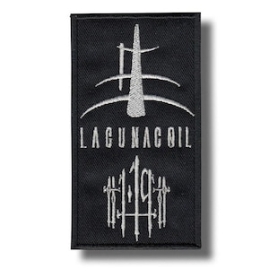 Puede incluir: Parche rectangular negro con texto y diseño bordados en blanco. El texto dice "LAGUNACOIL" sobre un gráfico estilizado y los números "119". El parche tiene un borde negro y una sombra.