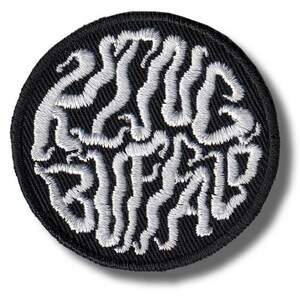 Puede incluir: Un parche redondo y negro bordado con las palabras "ZOMBIE BRAIN" en blanco, con letras estilizadas. El texto está en una fuente arremolinada y orgánica, creando un diseño único. El parche es para ropa o accesorios.