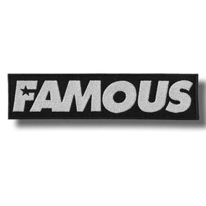 Peut inclure: Écusson rectangulaire noir avec le mot "FAMOUS" brodé en blanc, avec une étoile remplaçant le "A". Ce patch est destiné aux vêtements ou accessoires.