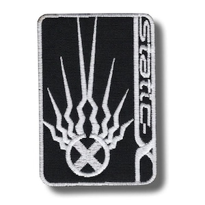 Könnte beinhalten: Rechteckiger, gestickter Aufnäher mit schwarzem Hintergrund und weißen Details. Das Design zeigt ein flammenartiges Muster über einem Kreis mit einem X darin. Das Wort "STATIC" ist vertikal auf der rechten Seite gestickt.