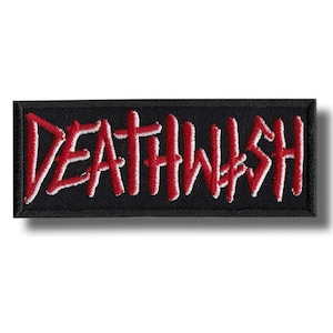 Può includere: Una toppa rettangolare nera con la scritta "DEATHWISH" ricamata in rosso con contorni bianchi. La toppa è destinata all'abbigliamento o agli accessori.