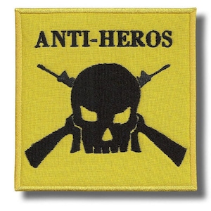 Puede incluir: Parche cuadrado amarillo con el texto "ANTI-HEROS" sobre una calavera negra con rifles cruzados. El parche tiene un borde amarillo y es probablemente un diseño bordado.