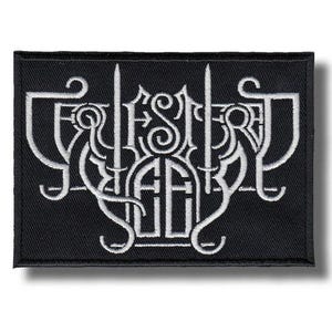 Puede incluir: Parche rectangular negro con texto bordado en blanco. El texto está estilizado con letras ornamentadas de inspiración gótica. El parche tiene un diseño limpio y minimalista, centrado en los intrincados detalles del texto.