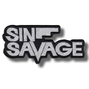 May include: Embroidered black patch featuring the text "SIN SAVAGE" in white, bold lettering. The patch has a black border and a shadow effect, giving a 3D look. Suitable for application on clothing or accessories.