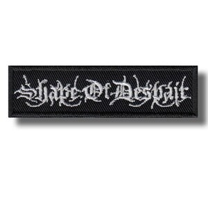 以下が含まれることがあります： ゴシック体で「Shade of Despair」と白く刺繍された長方形の黒いパッチ。 パッチは黒い縁取りがあり、衣類やアクセサリー用です。