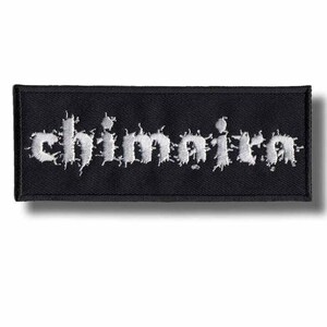 May include: A rectangular black patch with the word "chimaira" embroidered in white, stylized, gothic lettering. The patch has a black border and is likely designed to be sewn onto clothing or accessories.