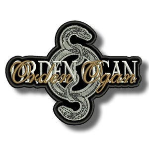 Puede incluir: Parche bordado con las palabras "Orden Ogan" en letras doradas y blancas. Un diseño de serpiente plateada está centrado sobre un fondo negro, con un borde negro. El parche tiene un efecto de sombra.