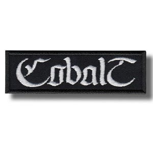 May include: Black rectangular patch with the word "Cobalt" embroidered in white gothic lettering. The patch has a black border and is likely designed to be sewn or ironed onto clothing or accessories.