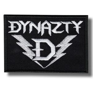 May include: A black rectangular patch featuring the word "DYNAZTY" in white, gothic-style lettering. Beneath the word is a white lightning bolt design with a large white letter "D". This patch is likely for a band or clothing.