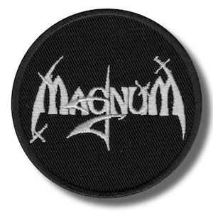Könnte beinhalten: Ein runder, schwarzer, gestickter Aufnäher mit dem Wort "MAGNUM" in weißer, stilisierter Schrift. Das Design beinhaltet kleine kreuzartige Symbole. Der Aufnäher hat eine strukturierte Oberfläche.
