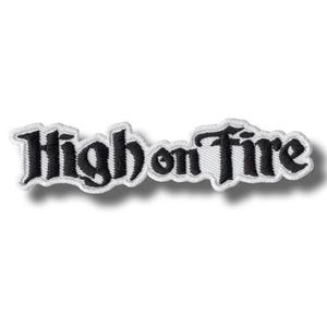 Op de afbeelding: Geborduurde patch met de tekst "High on Fire" in zwart script met een witte rand. De patch is rechthoekig en heeft een witte achtergrond.
