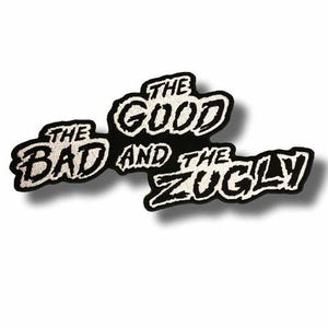 Op de afbeelding: Een zwart-wit geborduurde patch met de tekst "THE BAD AND THE GOOD AND THE ZUGLY". De patch heeft een zwarte rand en witte letters. De achtergrond is wit.