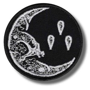 Op de afbeelding: Een ronde zwarte patch met een wit geborduurde maan en drie witte druppelvormen. Het maanontwerp heeft gedetailleerde witte borduursels. De patch heeft een zwarte rand en is waarschijnlijk om op te strijken of op te naaien.