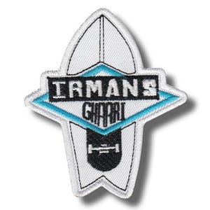 Pode incluir: Patch bordado em forma de prancha de surf, com o texto "IRMANS GHARBI" em preto e branco. O design inclui uma forma de diamante azul turquesa e um gráfico de skate preto na parte inferior. O patch tem uma borda branca.