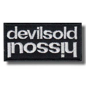 Könnte beinhalten: Schwarzer rechteckiger Aufnäher mit weiß gesticktem Text, der „devilsold“ über „nossiu“ lautet. Der Aufnäher hat einen schwarzen Rand und einen Schatteneffekt.
