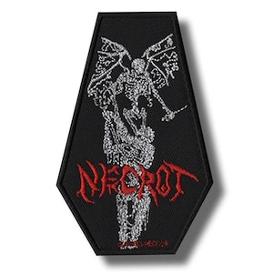 Könnte beinhalten: Schwarzer, Sarg-förmiger Aufnäher mit einer geflügelten Skelettfigur und dem roten Wort "NECROT". Das Design ist in Weiß und Rot gestickt. Ideal zum Aufnähen auf Kleidung oder Taschen.