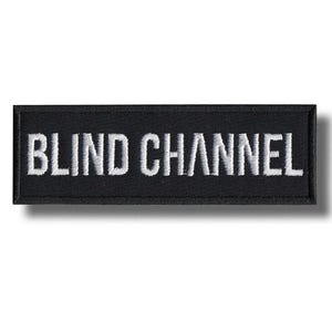 Op de afbeelding: Zwart rechthoekig embleem met de geborduurde tekst "BLIND CHANNEL" in wit. Het embleem heeft een zwarte rand en een schaduweffect. Het embleem is waarschijnlijk bedoeld voor kleding of accessoires.