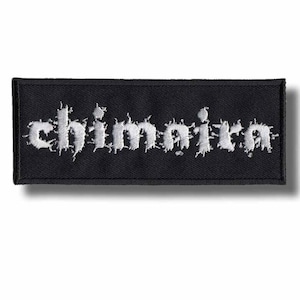 May include: Black rectangular patch with the word "Chimaira" embroidered in white. The text has a distressed, spiky font style. The patch is likely for clothing or accessories.