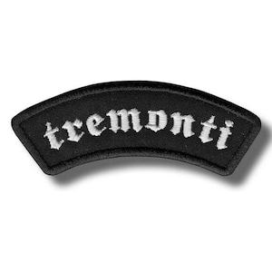 以下が含まれることがあります： 黒色のアーチ型パッチ。白いゴシック体で「tremonti」の文字が刺繍されています。パッチは黒い縁取りがあり、わずかな影の効果があり、立体的に見えます。