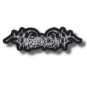 Pode incluir: Patch bordado preto com texto branco estilizado. O patch tem uma borda preta e um design branco e intrincado. O texto parece ser o nome ou logotipo de uma banda. O patch é retangular com bordas curvas.