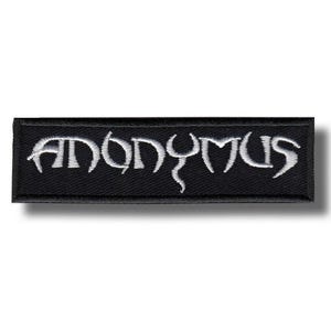 May include: A black rectangular patch featuring the word "ANONYMOUS" embroidered in white, using a gothic font. The patch has a white border and is designed to be sewn or ironed onto clothing or accessories.