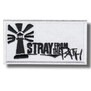Könnte beinhalten: Gestickter Aufnäher mit einem schwarzen Leuchtturm-Design und dem Text "STRAY FROM THE PATH" in Schwarz. Der Aufnäher befindet sich auf einem weißen Hintergrund mit weißem Rand. Der Leuchtturm hat strahlende Lichtstrahlen.