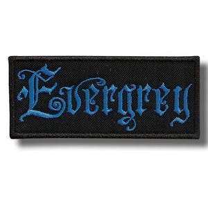Könnte beinhalten: Schwarzer rechteckiger Aufnäher mit dem Wort "Evergrey" in blauer gotischer Schrift gestickt. Der Aufnäher hat einen schwarzen Rand und ist wahrscheinlich aus Stoff.