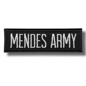 May include: A rectangular black patch with white embroidered text that reads "MENDES ARMY". The patch is likely made of fabric and has a stitched border. The text is in a sans-serif font.