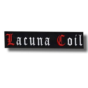 Può includere: Toppa rettangolare nera ricamata con il nome della band "Lacuna Coil". Il testo è in un carattere gotico, con la prima e l'ultima lettera in rosso e il resto in bianco.