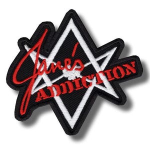 Könnte beinhalten: Gestickter Aufnäher mit dem Text "Jane's Addiction" in roter Schrift. Der Aufnäher hat einen schwarzen Hintergrund mit einem weißen Sterndesign und einem schwarzen Rand. Geeignet für Kleidung oder Accessoires.